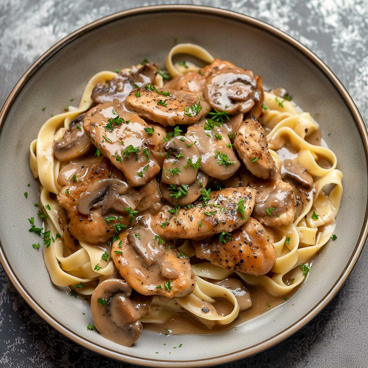 Chicken marsala on tagliatelle pasta.